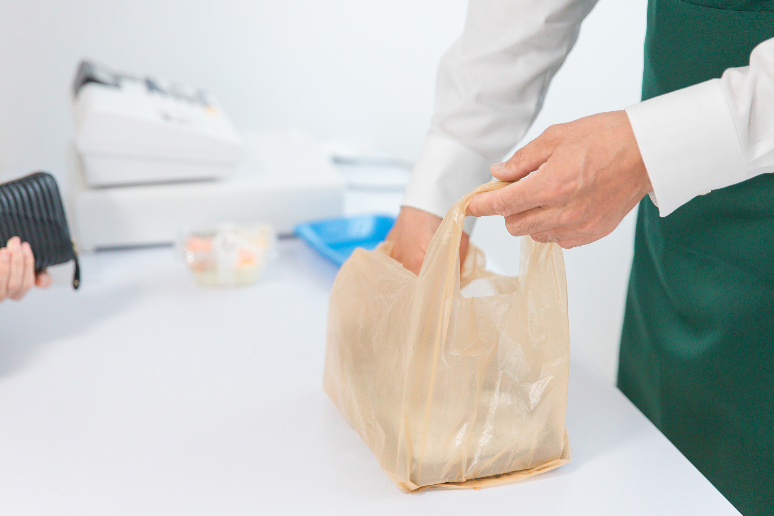 コンビニでお金を払う女性とレジを打つ男性